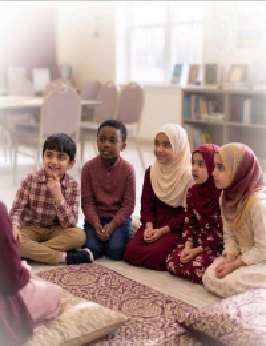Children sitting together with copies of the Qur'an during a class